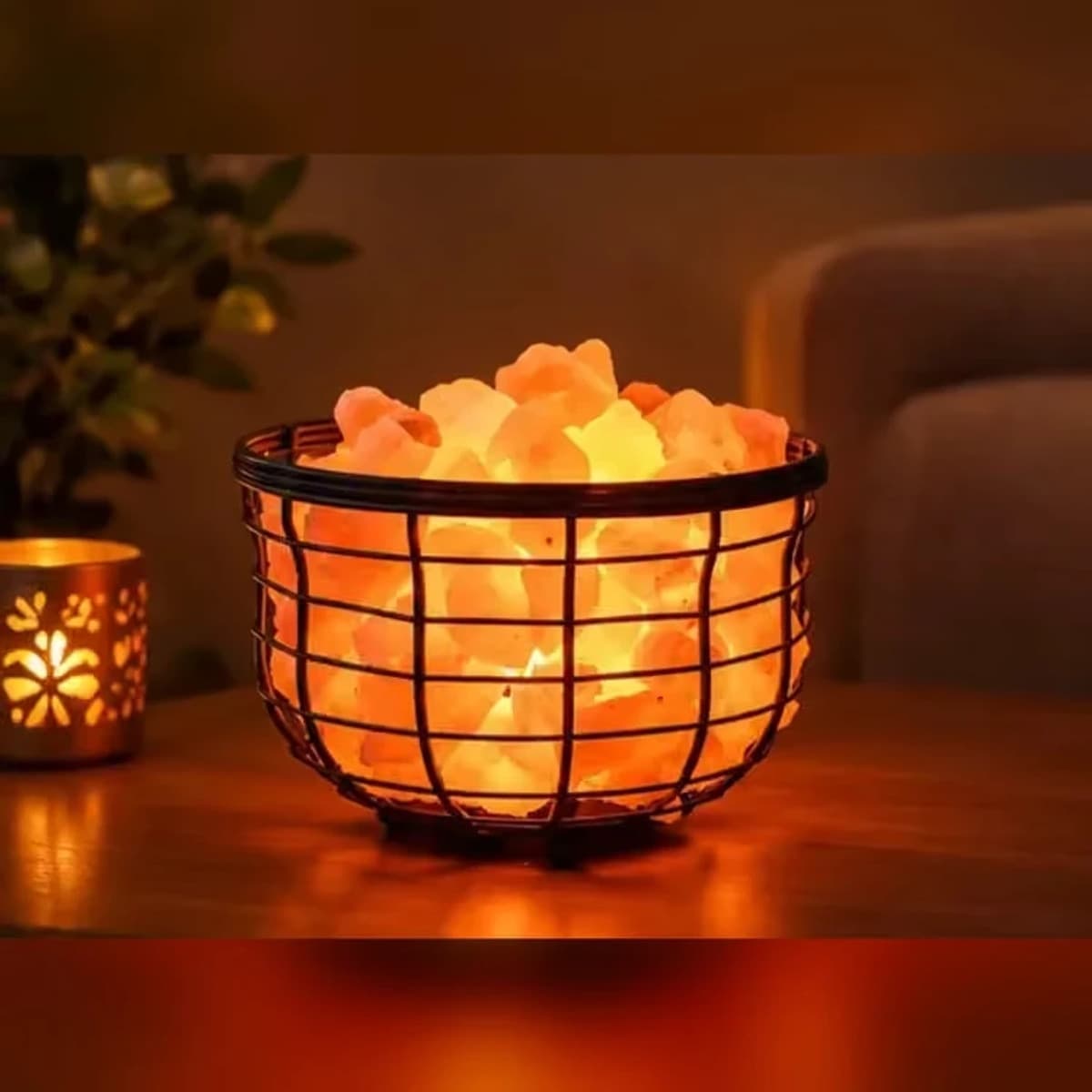 Himalayan pink salt basket lamp glowing warm orange on a side table in the evening